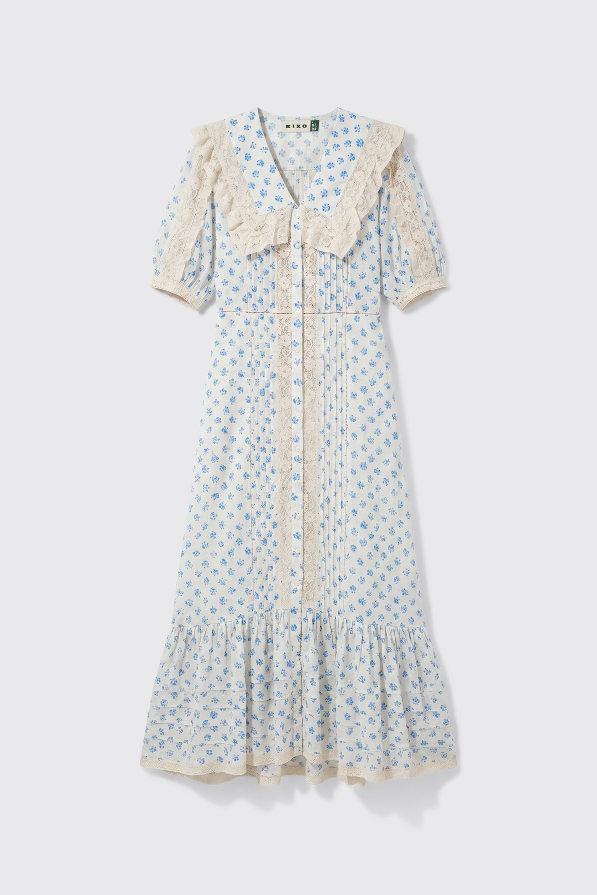 Edina - Seville Floral Cream dress featuring light blue floral patterns, short sleeves, lace trim, a large lace collar, front buttons, and a ruffled hem, displayed on a white background.