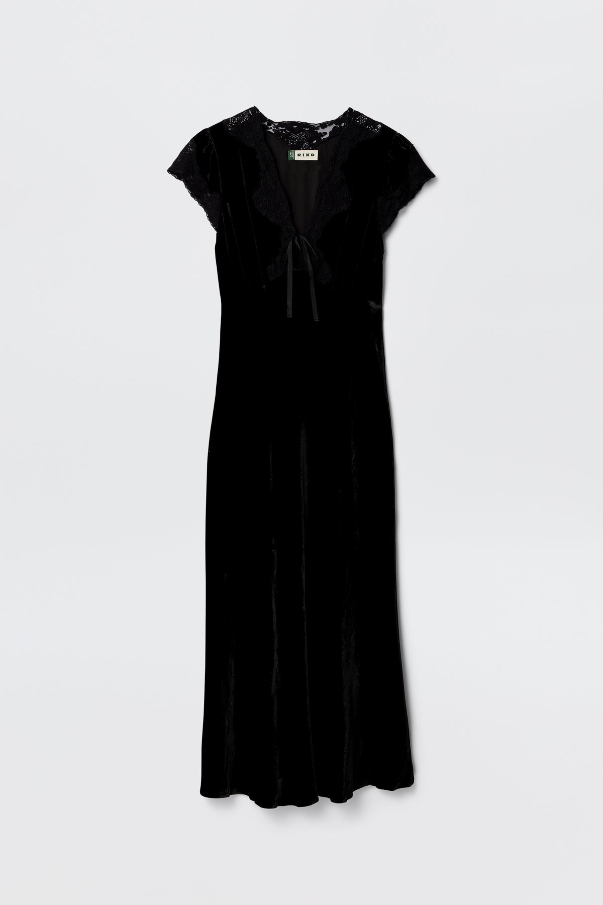 The Amari - Black dress features black velvet, an adjustable V-neck, short lace sleeves, lace trim at the shoulders and neck, and a ribbon bow tie detail at the front, shown against a plain white background.