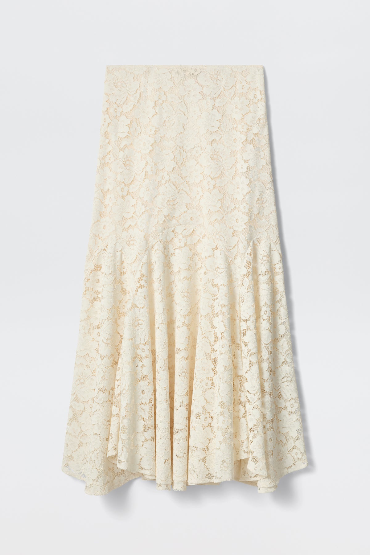 The Jada - Cream is a mid-length cream lace skirt featuring a fitted waist and flared, flowing hem, showcased against a plain white background.