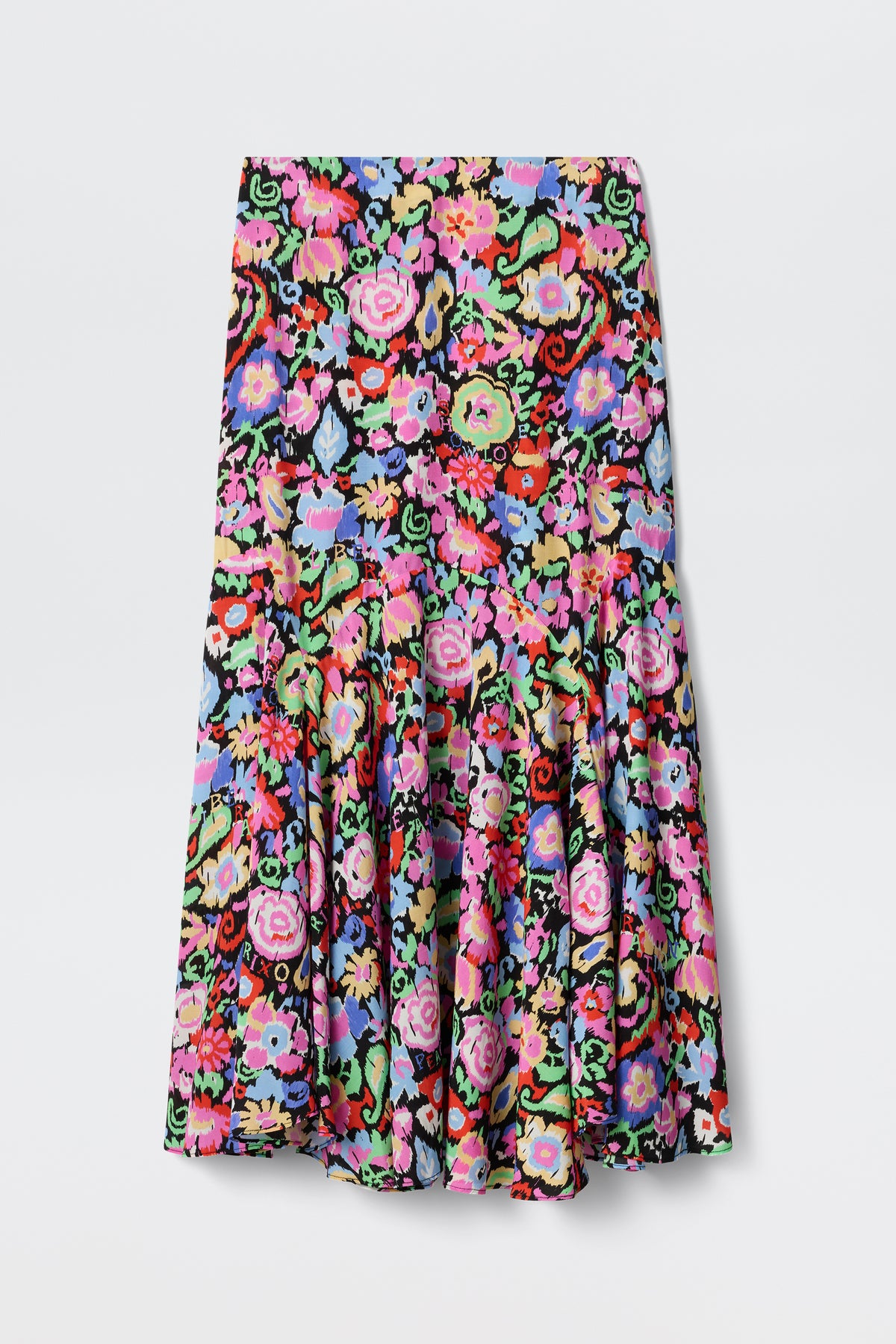 The Libbie - Ikat Bloom Charcoal skirt is knee-length with a vibrant multicolored floral pattern on a black background, featuring pink, red, purple, and green hues. It has a fitted waist and a flared, ruffled hem.