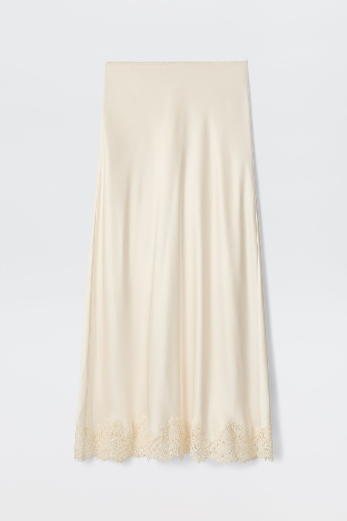 The Matilde - Pearl is a cream-colored satin slip skirt featuring delicate lace trim along the hem, ideal for a bridal look, shown against a plain white background.