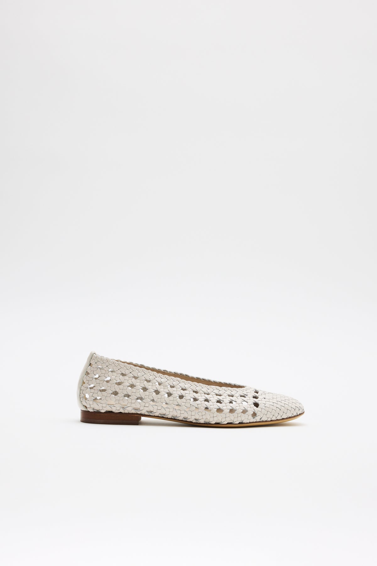 The Marlia - Cream is a light beige woven flat shoe featuring a perforated pattern and a small brown sole, shown against a plain white background.