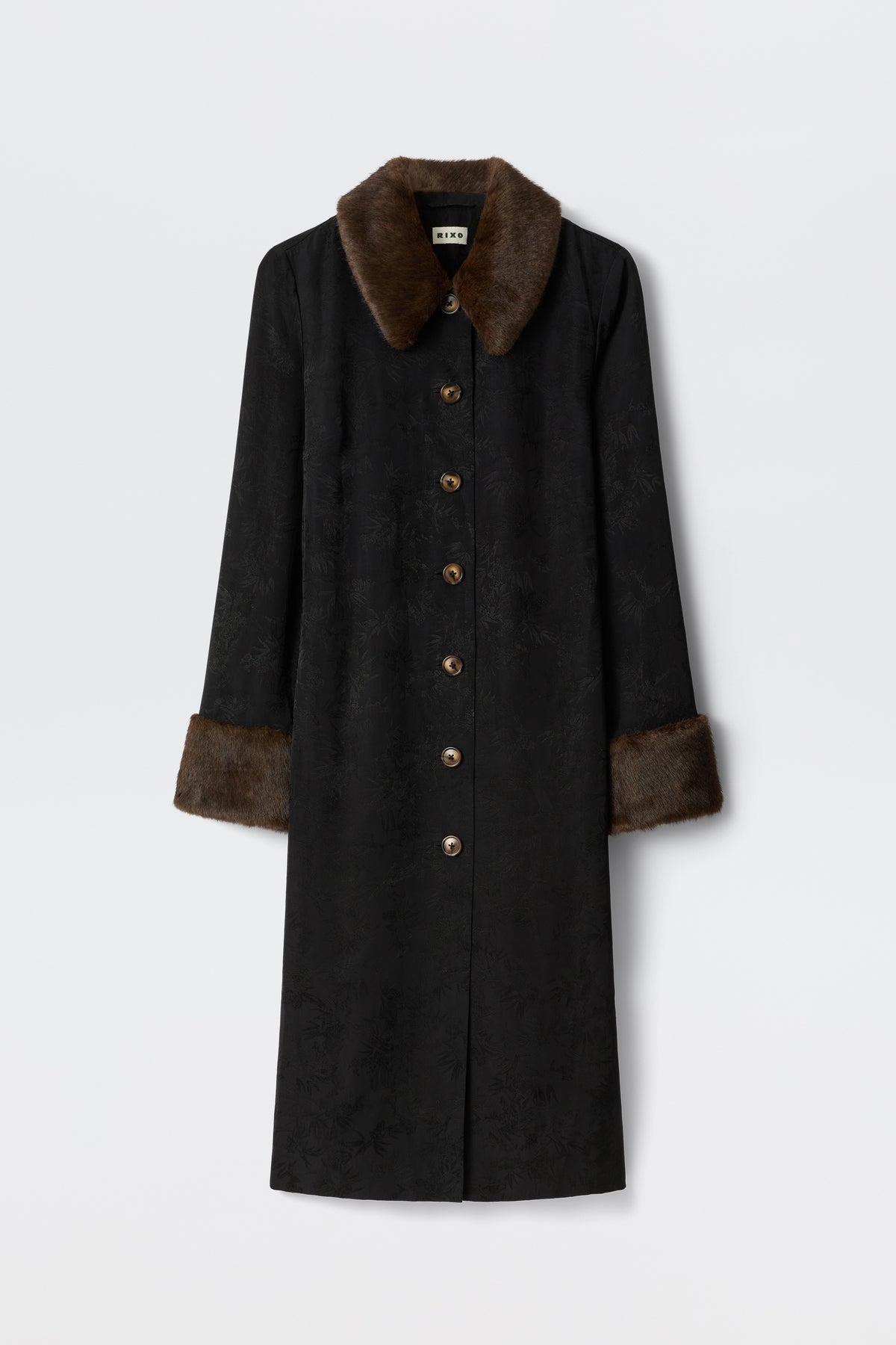 The Jonah - Black coat features a long black design with brown faux fur collar and cuffs, subtle textured pattern, and brown front buttons, shown against a plain white background.