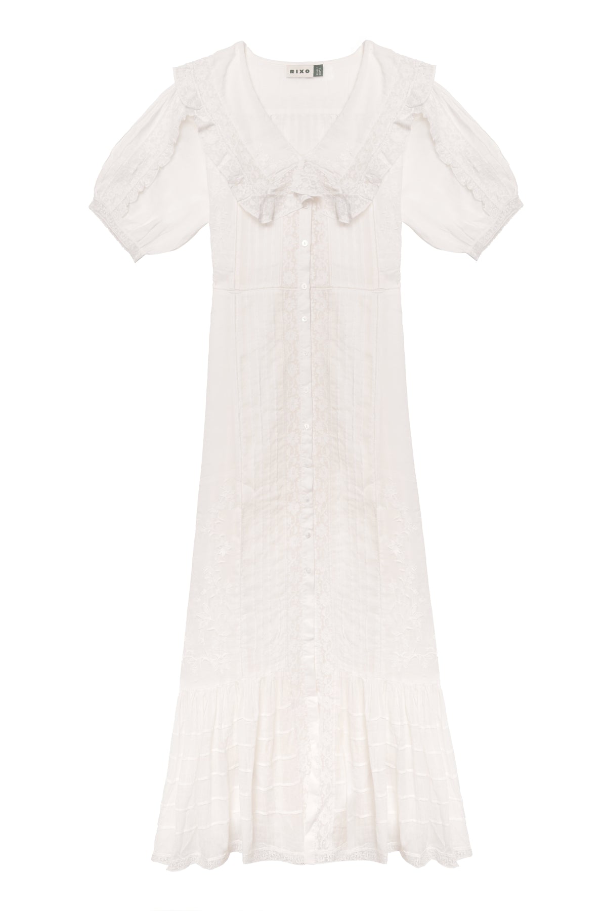 The Edina - Pansy Embroidery White dress features short sleeves, a ruffled collar, button-down front, midi length, delicate lace embroidery, flared hem, and an adjustable waist for a vintage-inspired look.