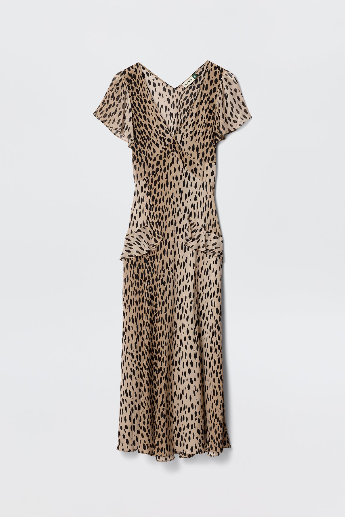 The Evie - Antelope Spot Black dress features a beige base with black irregular spots, short sleeves, V-neck, and midi length, offering a bohemian animal print vibe. Shown against a plain white background.