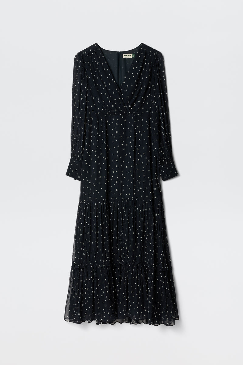 The Elsie - Starry Night Navy is an ankle-length, long-sleeved dress with a V-neckline, white polka dots, tiered skirt, and lightweight fabric for effortless comfort.