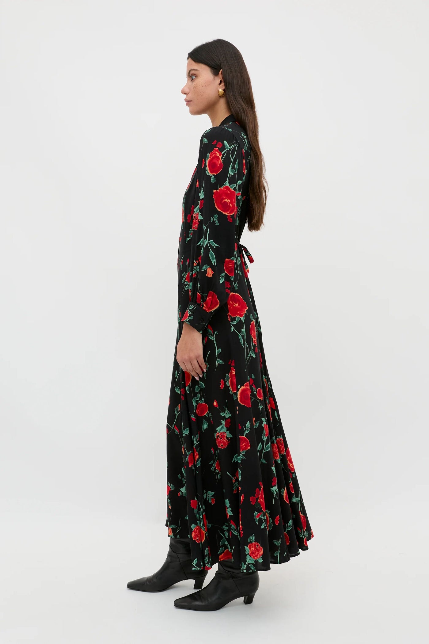 A petite woman in profile wears the Maddison - Claudia Rose Black shirt dress paired with black boots. She has long dark hair and faces left against a plain white background, showcasing effortless everyday style.