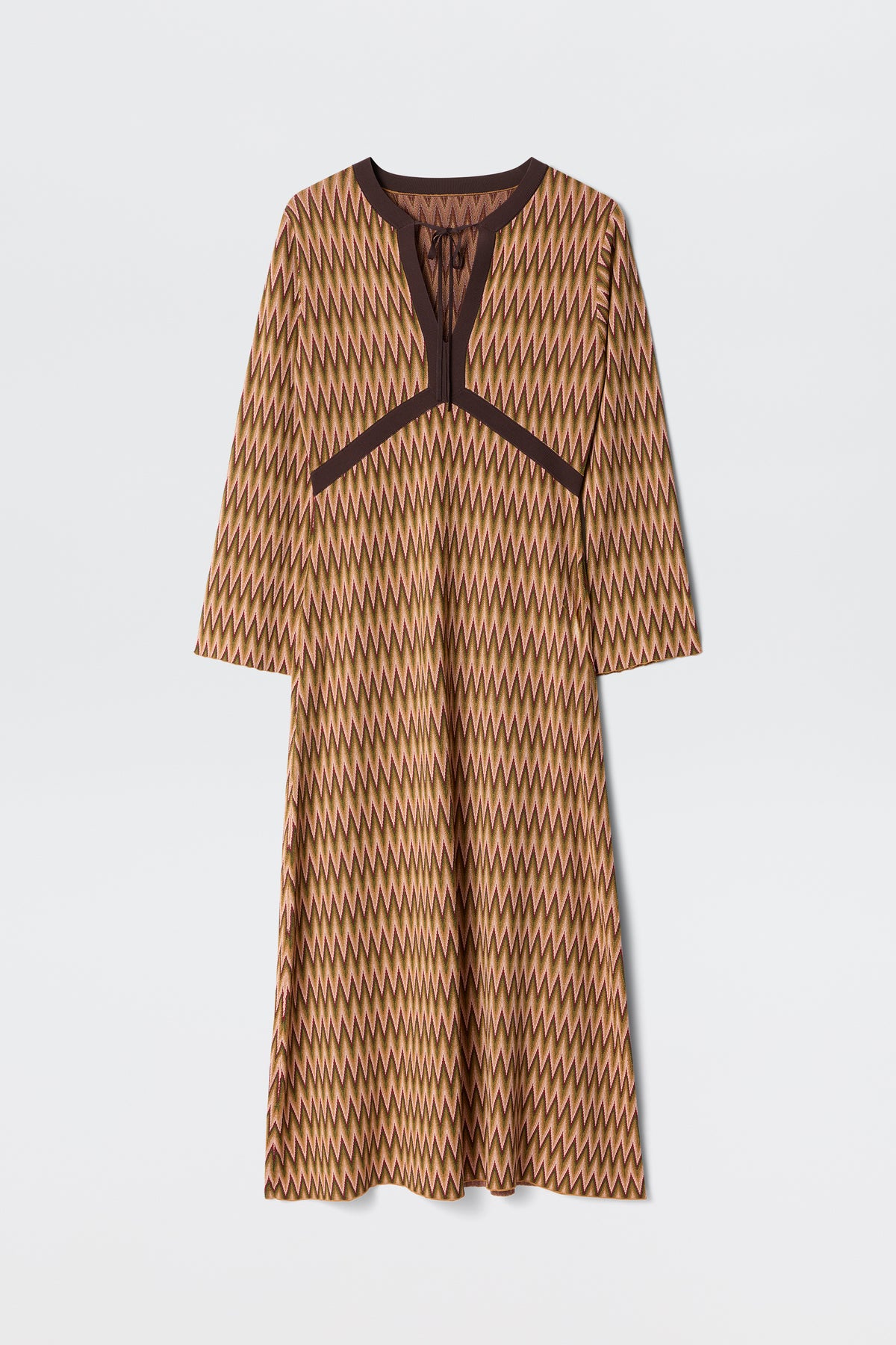The Pamela - Maeve Jacquard Multi is a long-sleeved, knee-length dress featuring a brown, yellow, and beige zigzag pattern with dark brown trim along the neckline and chest, shown on a plain white background.
