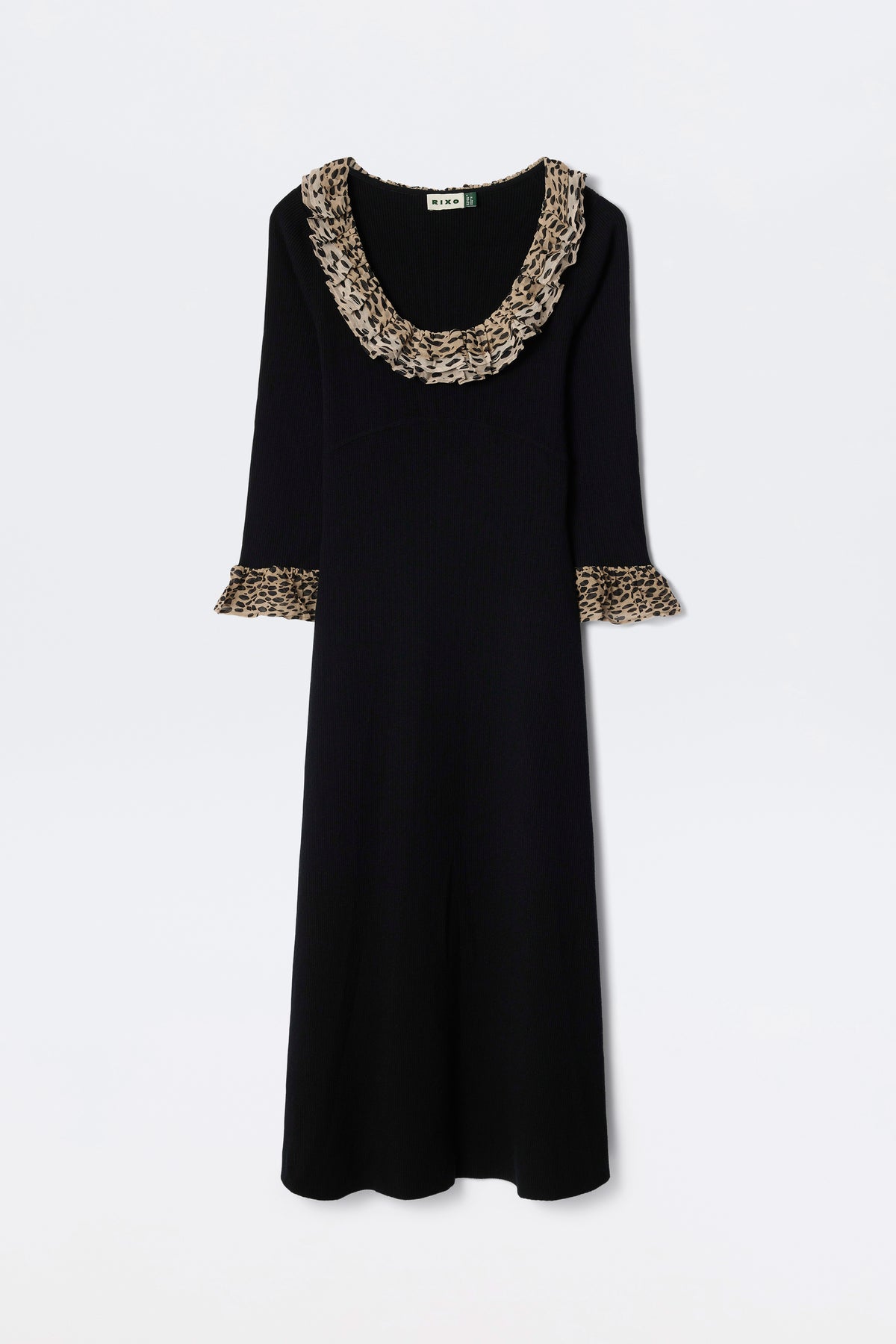 The Mika - Antelope Spot Black is a long-sleeved black scoop neck dress with wide ruffled neckline and sleeve cuffs, featuring a brown and black antelope spot print, displayed on a plain white background.