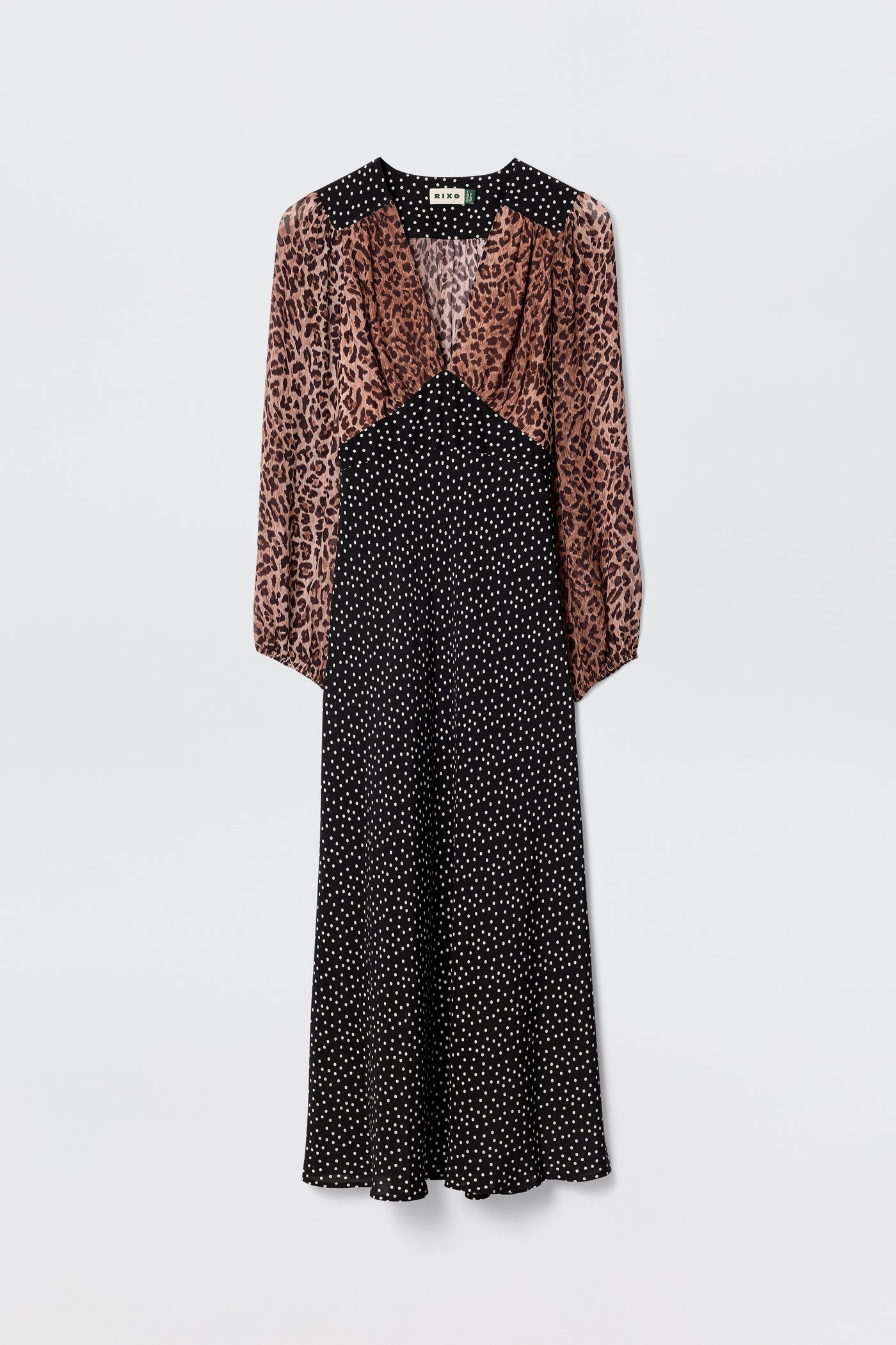 The Kaila - Leopard Spot Brown dress blends a brown and black leopard print top with a black polka dot midi skirt, featuring long sleeves, a V-neckline, and a slightly flared hem for a flattering silhouette.
