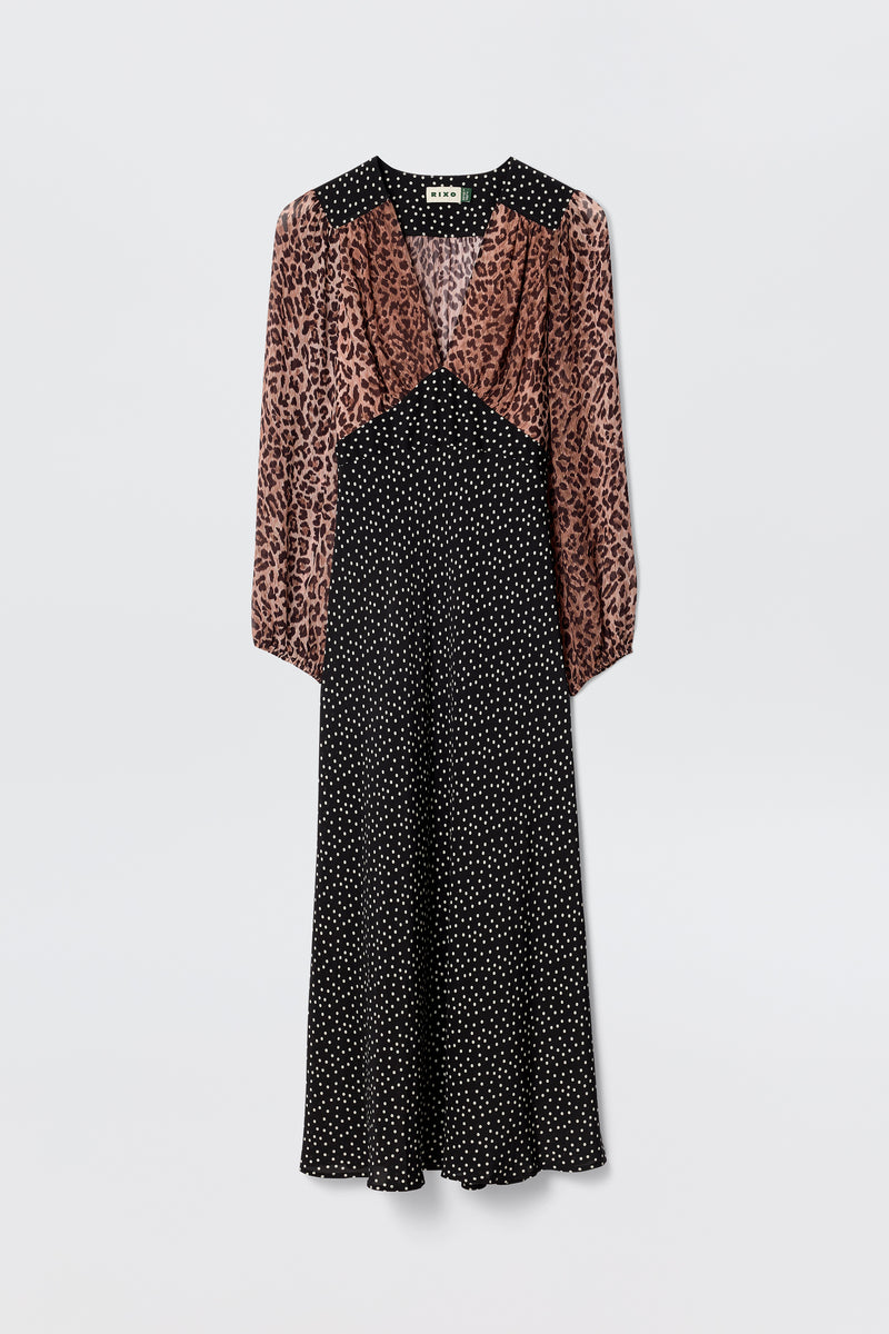 The Kaila - Leopard Spot Brown dress blends a brown and black leopard print top with a black polka dot midi skirt, featuring long sleeves, a V-neckline, and a slightly flared hem for a flattering silhouette.