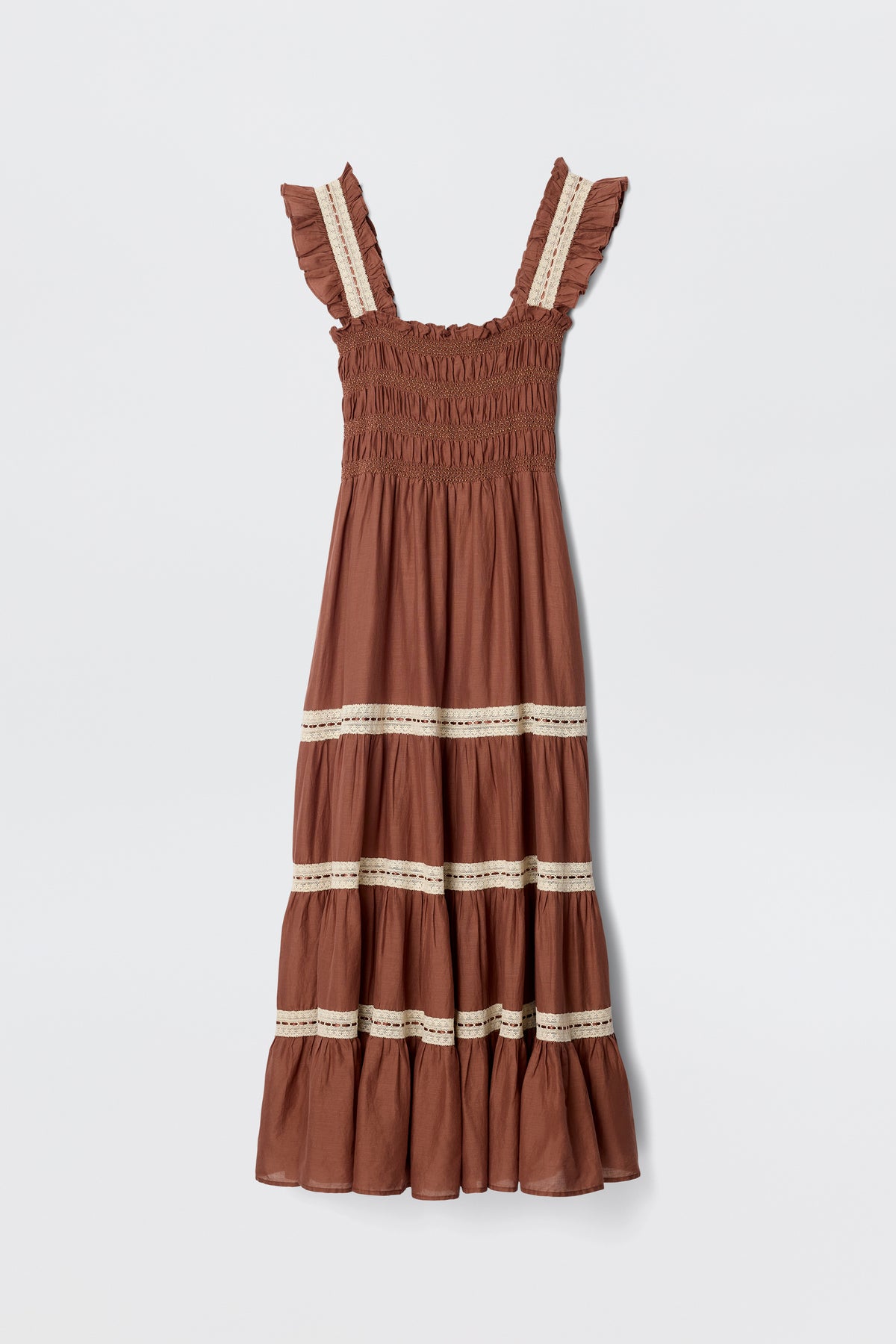 The Aubrie - Brown dress features ruffled straps, a smocked bodice, and a tiered skirt with cream lace crochet midi details, shown against a plain white background.
