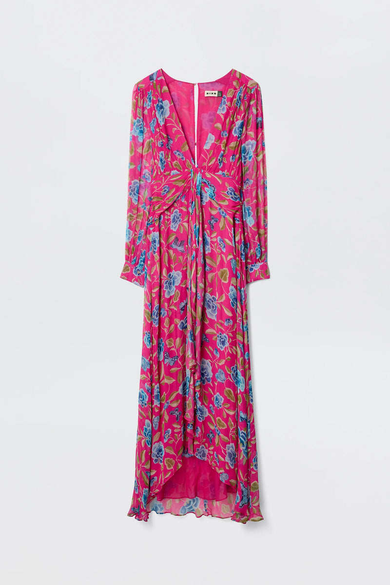 The Meera - Butterfly Floral Magenta features long sleeves, crinkled chiffon in pink with blue and green floral print, a V-neck, front twist detail, and ruffled high-low hem—a stunning choice for weddings or boho evenings. Shown on white background.