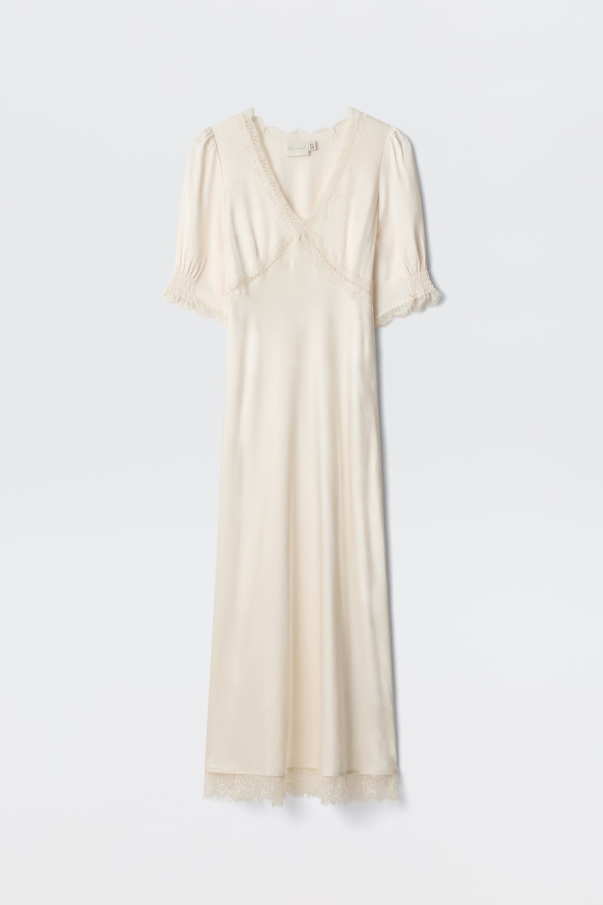 The Annina - Pearl is a cream satin dress with short puff sleeves, lace-trimmed neckline, sleeves, and hem, plus a subtle v-neckline. This vintage-inspired piece exudes elegant charm.