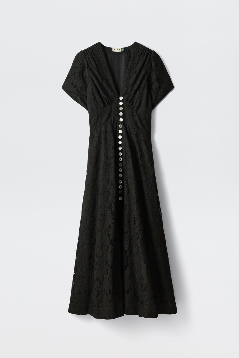 The Novara - Black is a black lace short-sleeve dress with a V-neckline, fitted bodice, flared skirt, and large round buttons down the front.
