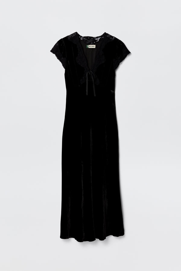 The Amari - Black dress features black velvet, an adjustable V-neck, short lace sleeves, lace trim at the shoulders and neck, and a ribbon bow tie detail at the front, shown against a plain white background.