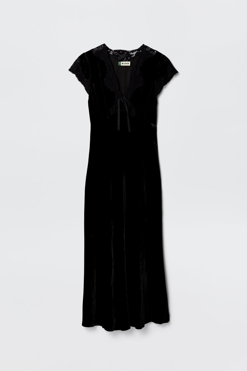 The Amari - Black dress features black velvet, an adjustable V-neck, short lace sleeves, lace trim at the shoulders and neck, and a ribbon bow tie detail at the front, shown against a plain white background.