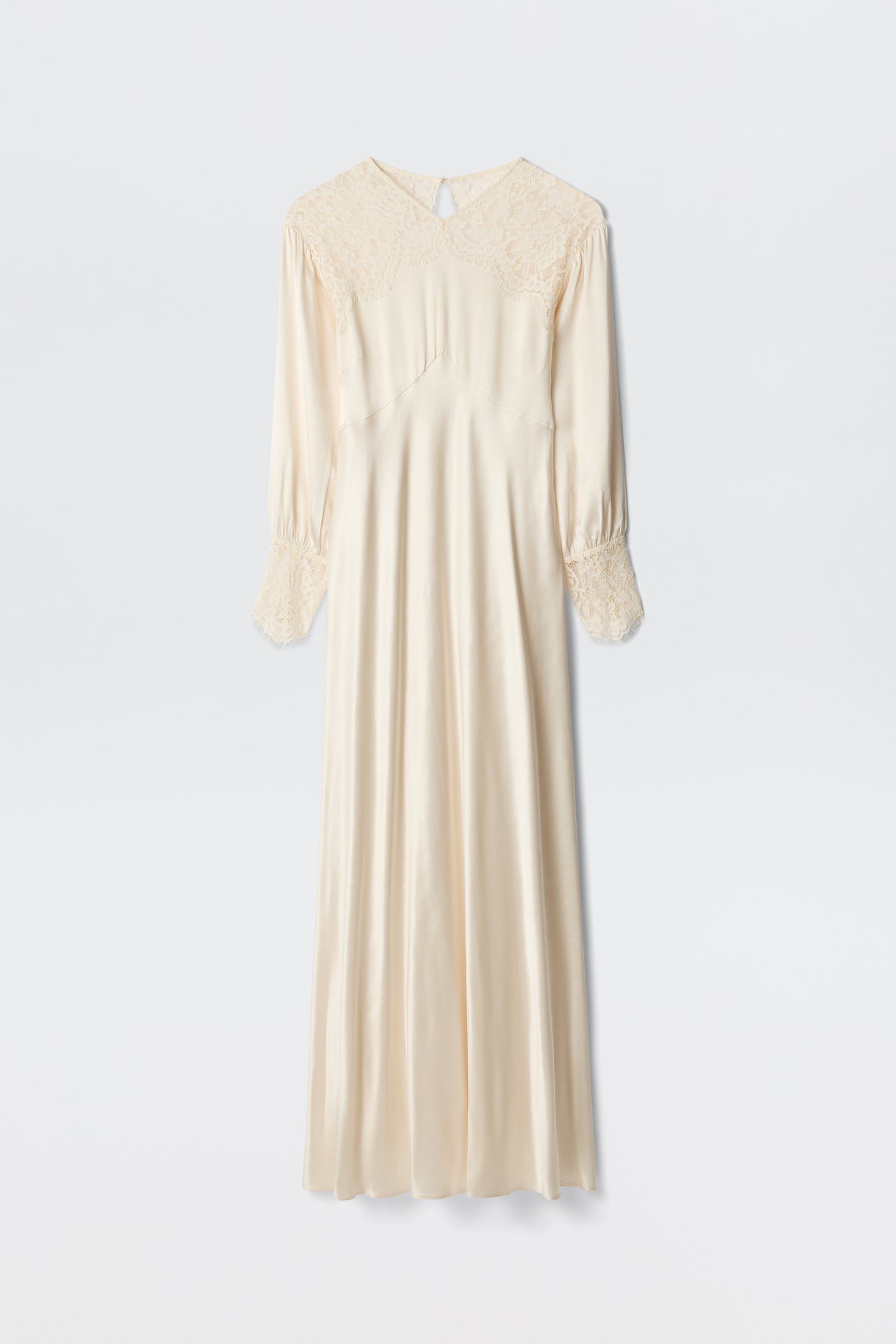 The Axelle - Pearl is an elegant long ivory satin dress featuring lace details on the shoulders and cuffs, long sleeves, and a loose, flowing silhouette. Photographed against a plain white background.