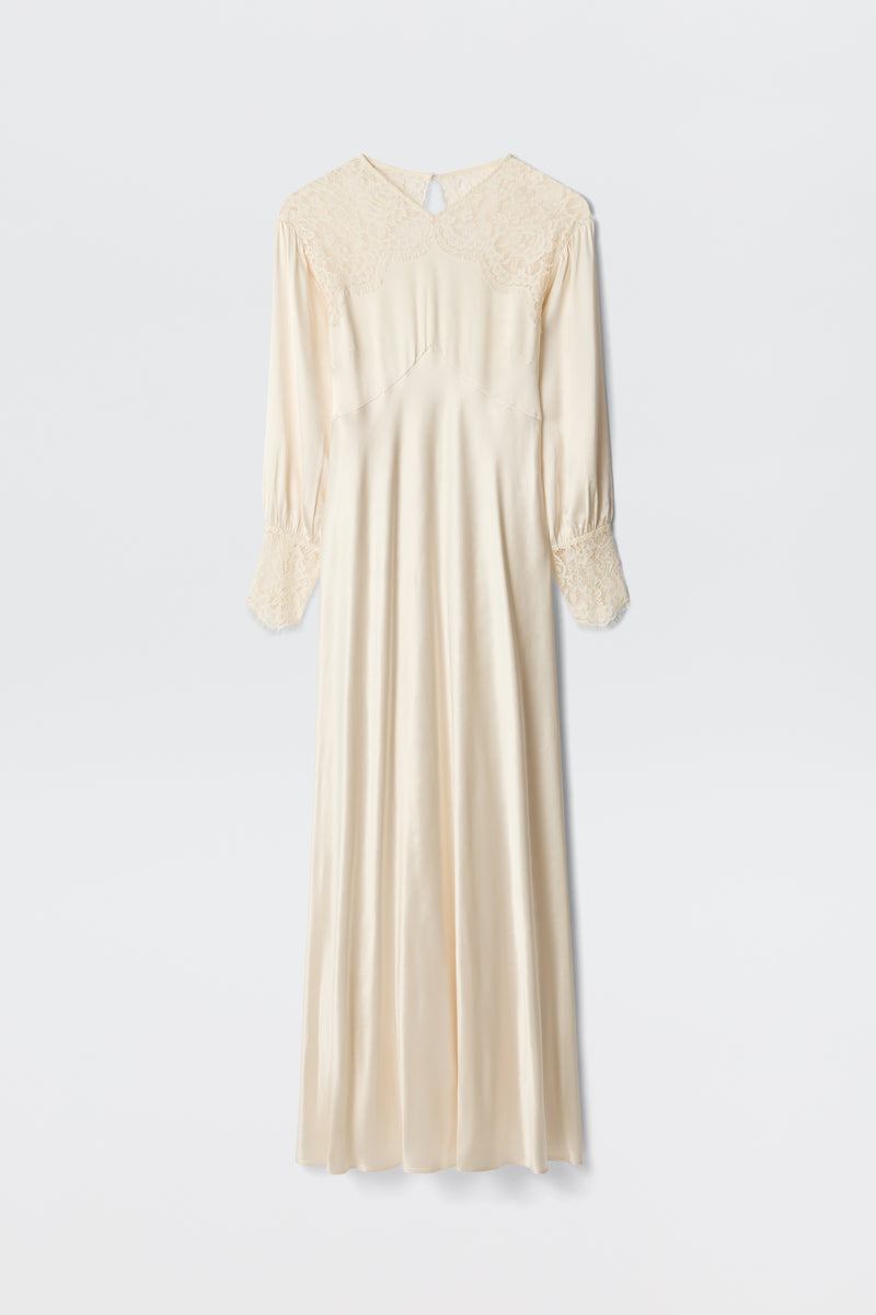 The Axelle - Pearl is an elegant long ivory satin dress featuring lace details on the shoulders and cuffs, long sleeves, and a loose, flowing silhouette. Photographed against a plain white background.