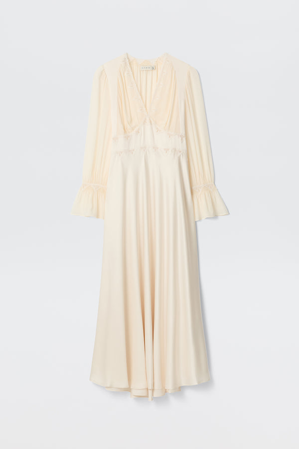 The Arlena - Pearl is a long cream satin dress with lace embroidery, long sleeves, V-neckline, ruffled cuffs, and a slightly flared hem displayed on a white background.