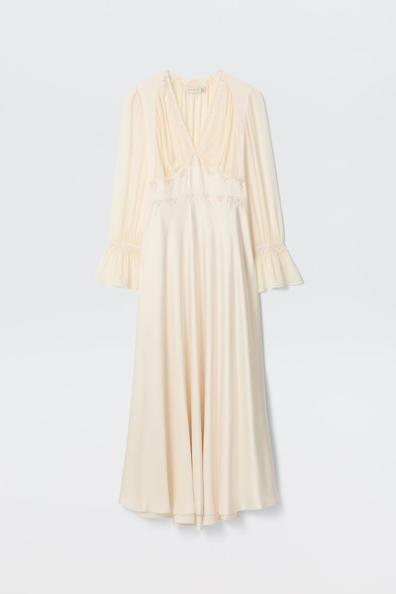 The Arlena - Pearl is a long cream satin dress with lace embroidery, long sleeves, V-neckline, ruffled cuffs, and a slightly flared hem displayed on a white background.