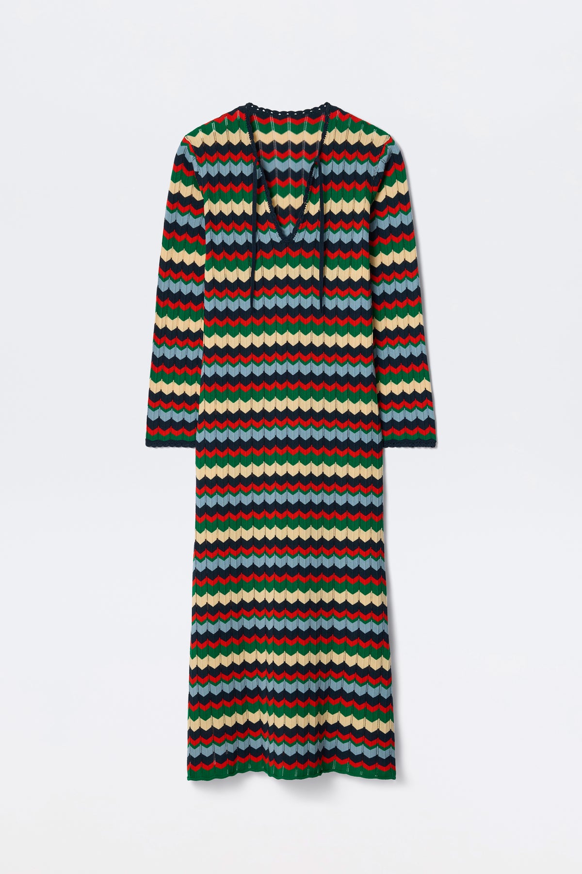 The Lucila - Retro Chevron Blue is a long-sleeved, ankle-length dress featuring a colorful wavy striped pattern in red, green, blue, and cream. It has a V-neck with a tie detail and offers a relaxed fit.