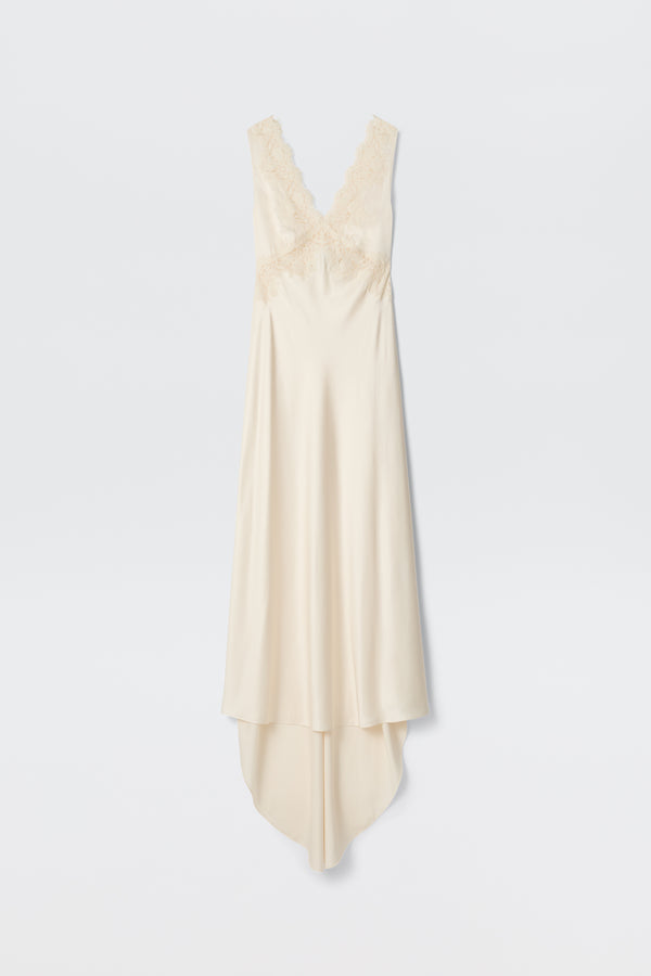 Azzurra - Pearl: A sleeveless, ivory vintage slip dress with lace-trimmed V-neckline and bodice, featuring an asymmetrical flowing hem, displayed on a plain white background.