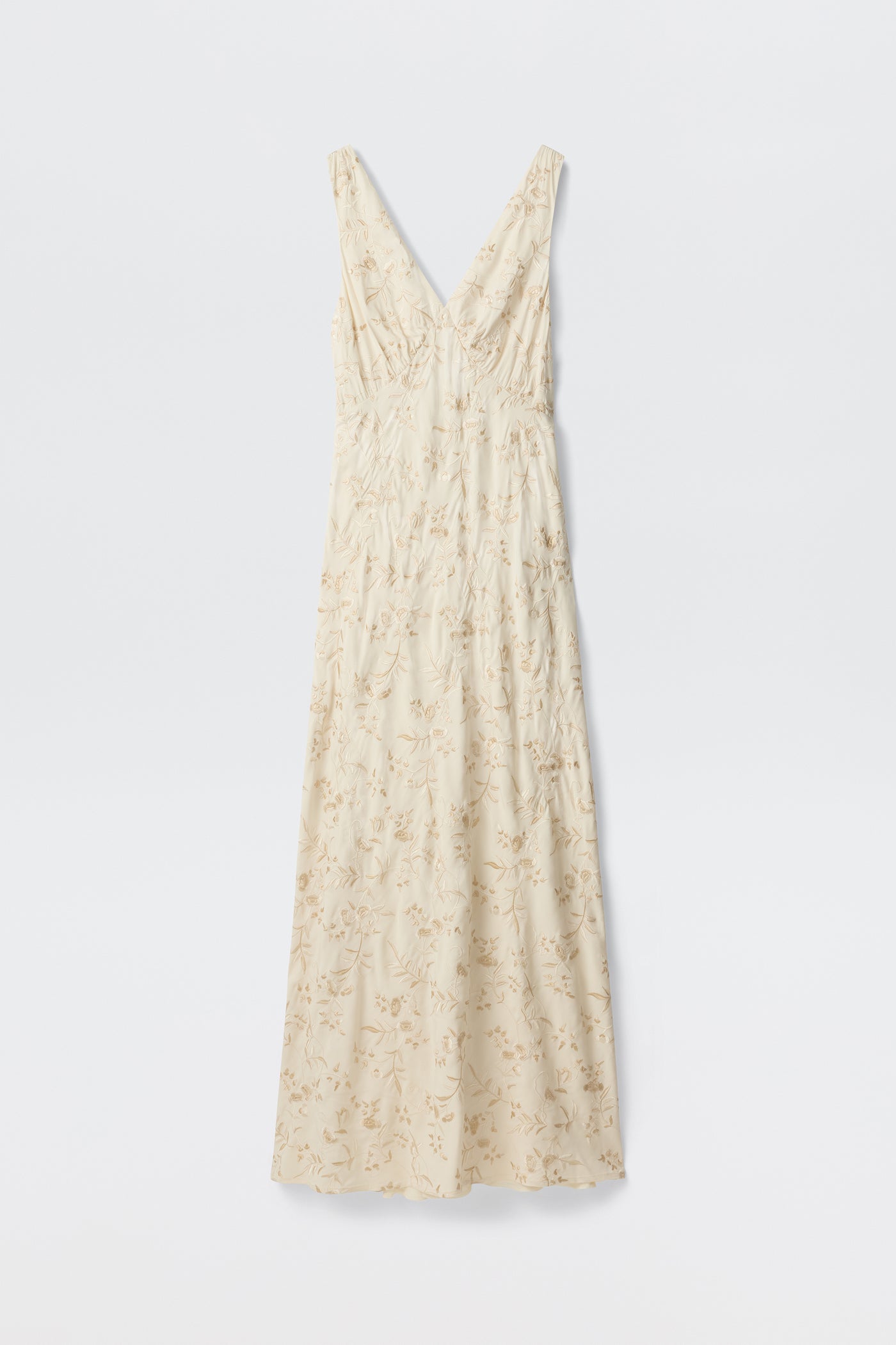 The Fawn - Botanical Embroidery Pearl is a sleeveless, cream maxi dress with a V-neckline, delicate light floral embroidery, and a form-fitted silhouette, displayed against a plain white background.