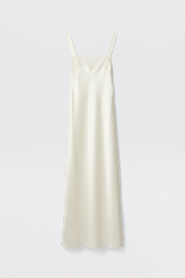 The Maybelle - Ivory is a long, cream-colored satin slip dress with wide shoulder straps and delicate lace trim on the straight neckline, shown against a plain white background.