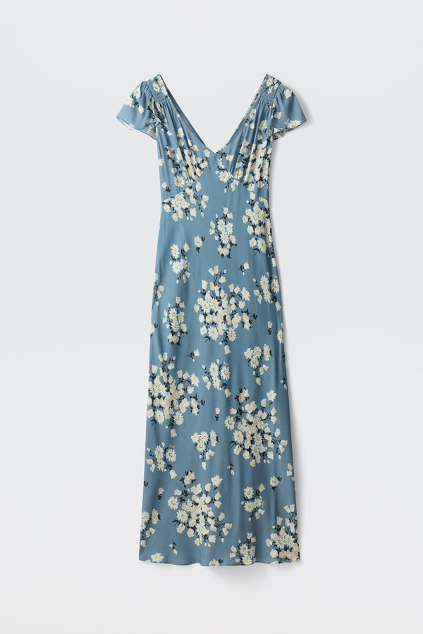 The Cathy - Amelia Bouquet Blue is a blue, short-sleeved V-neck maxi dress featuring a white and yellow floral print, shown laid flat on a white background.