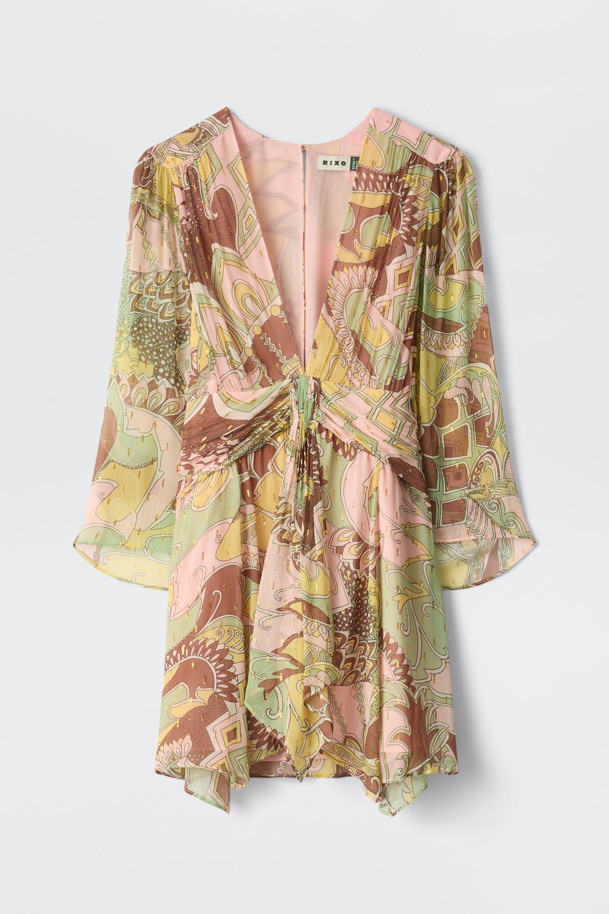 The Clove - Bianca Abstract Green is a flowy, V-neck mini dress with long sleeves, a front tie detail, and a loose fit. It features a colorful abstract pattern in pink, yellow, green, and brown.
