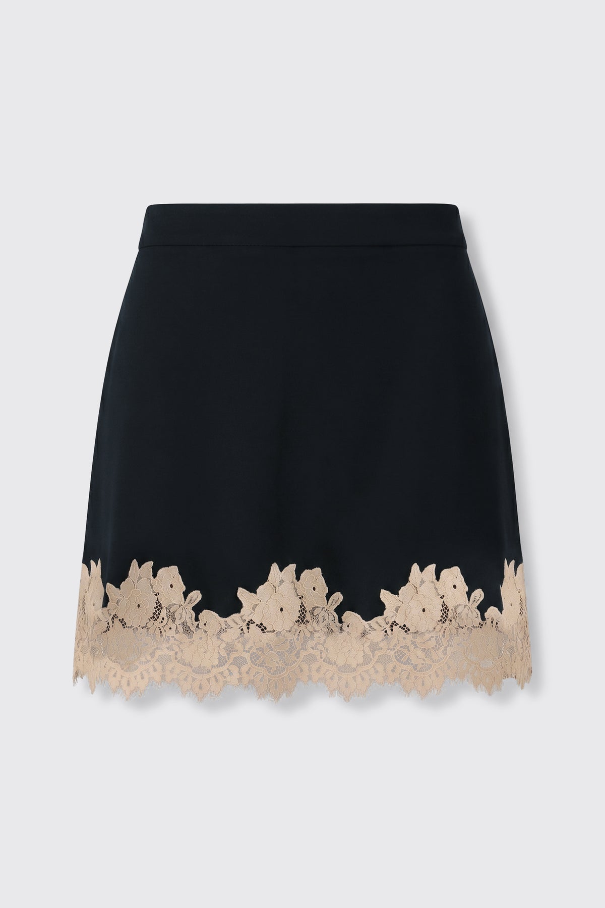 Ariah - Black: A black mini skirt adorned with a scalloped beige lace trim featuring a delicate floral pattern along the hem, displayed on a plain light background.