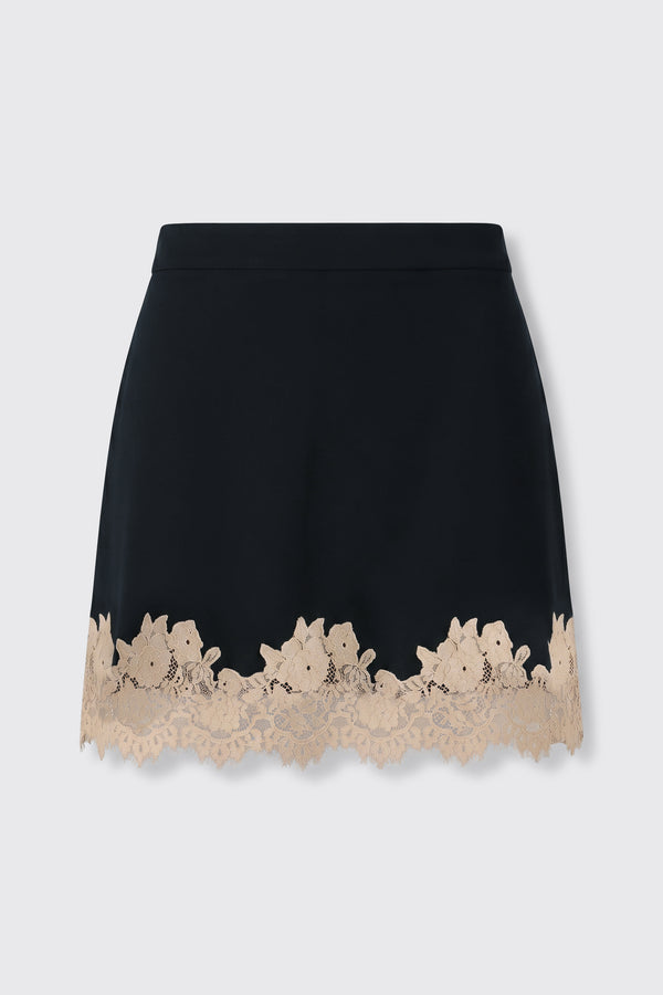Ariah - Black: A black mini skirt adorned with a scalloped beige lace trim featuring a delicate floral pattern along the hem, displayed on a plain light background.
