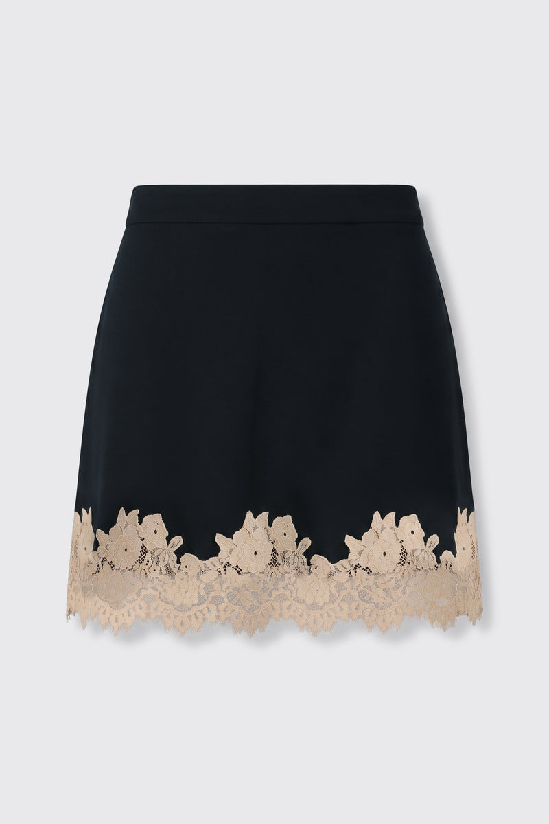 Ariah - Black: A black mini skirt adorned with a scalloped beige lace trim featuring a delicate floral pattern along the hem, displayed on a plain light background.