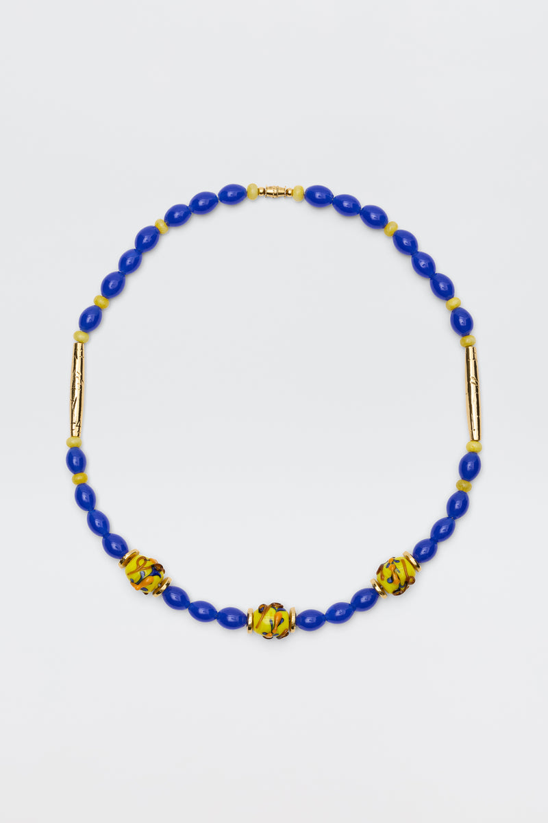 Denali - Multi necklace featuring blue oval beads, three yellow and green patterned round beads, and two gold-plated bead accents, beautifully displayed on a white background.