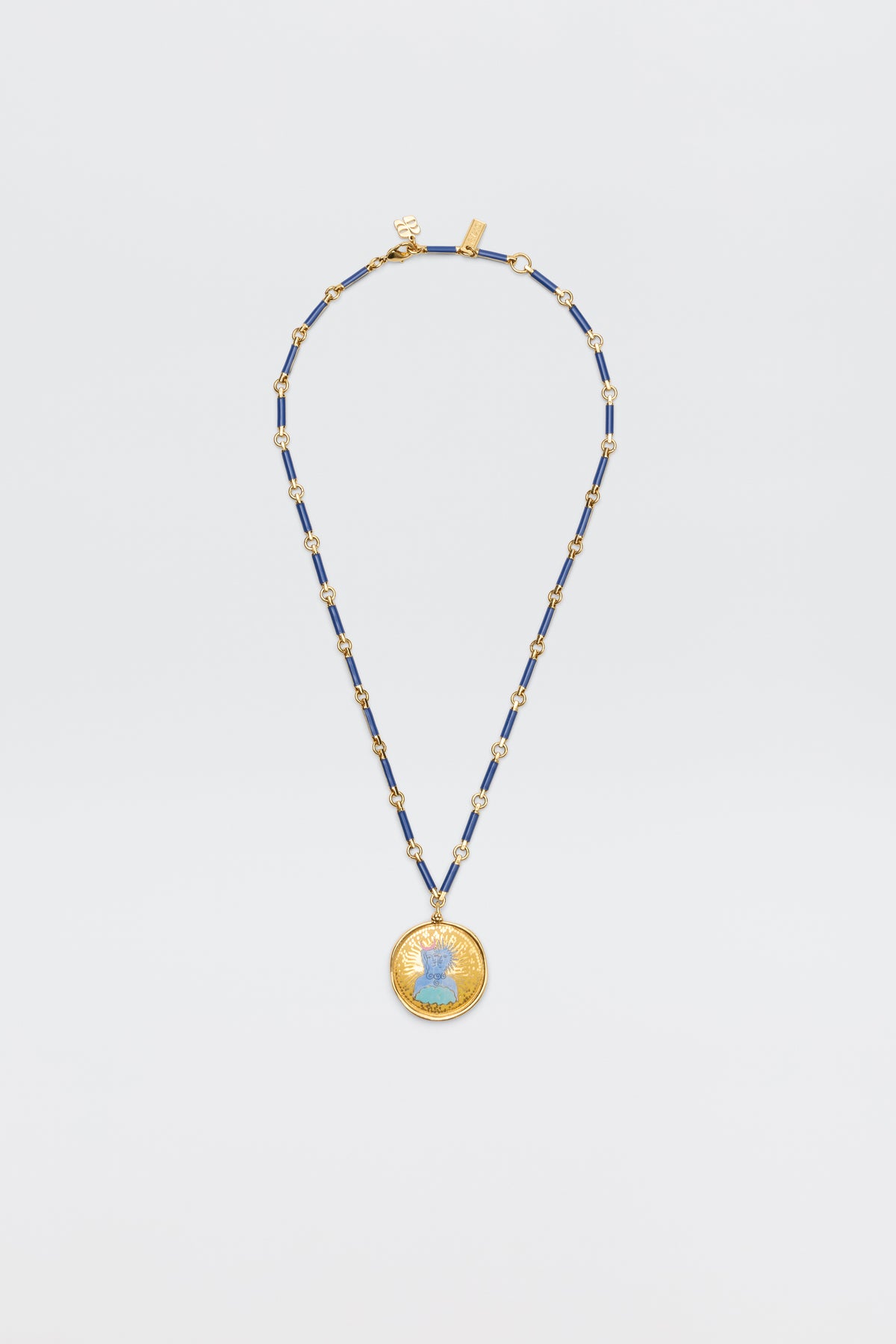 The Ari - Astro Gemini necklace features alternating blue and gold rectangular beads and a large round disc charm with a blue woman's profile at the center, shown against a plain white background.