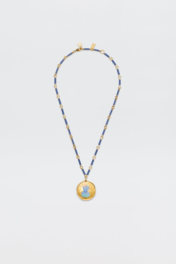 The Ari - Astro Gemini necklace features alternating blue and gold rectangular beads and a large round disc charm with a blue woman's profile at the center, shown against a plain white background.
