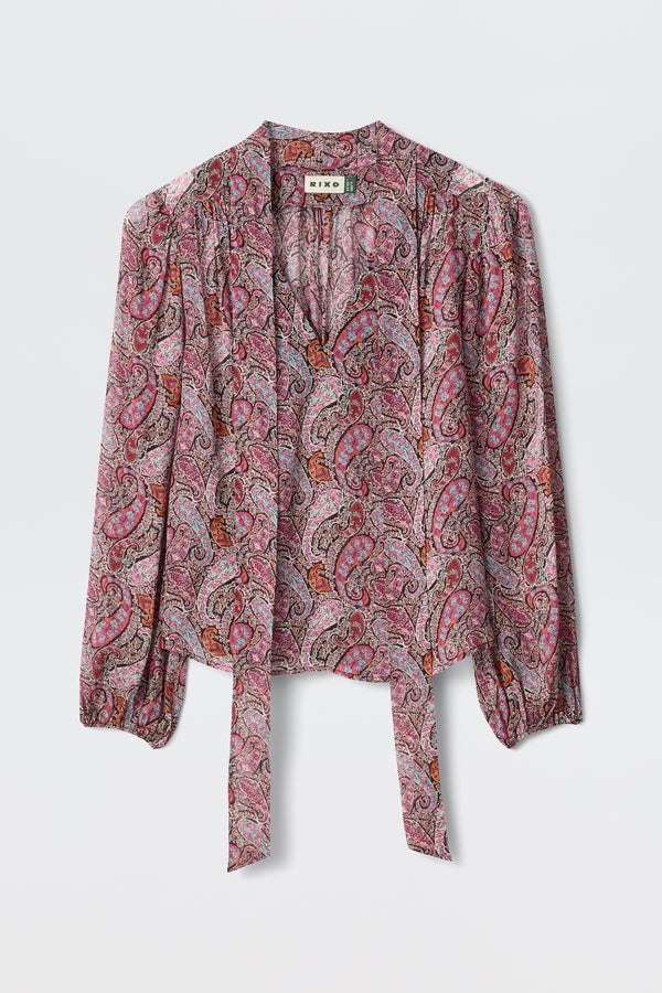 A long-sleeve Moss - Bourton Red georgette blouse with a pink, red, and purple paisley pattern, featuring a tie-front and slight gathering at the shoulders, displayed against a white background.