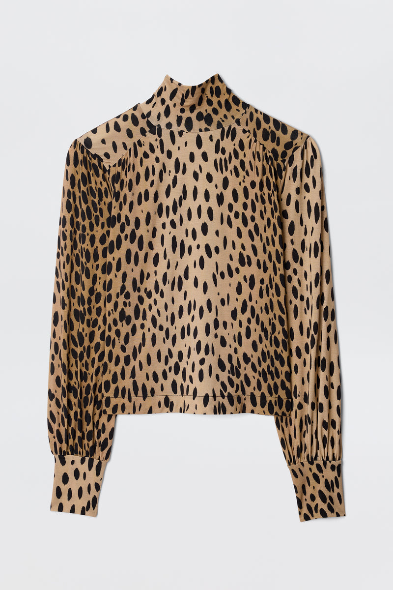 The Suki - Antelope Spot Black is a long-sleeve, high-neck top featuring a tan base with bold black and brown antelope print spots, shown flat on a white background.