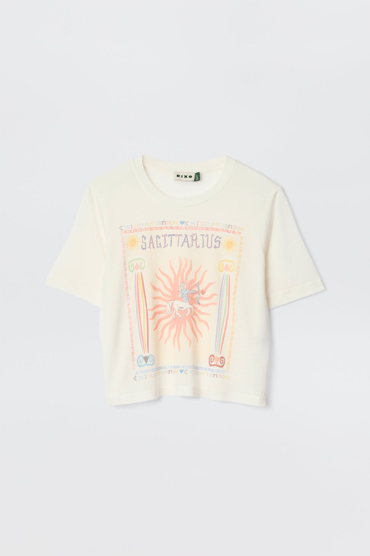 The Ria - Sagittarius is a white short-sleeve t-shirt with a colorful Sagittarius illustration, sun, rainbow, and astrological symbols on the front—perfect with RIXO skirts or styled with a trendy cropped hem.