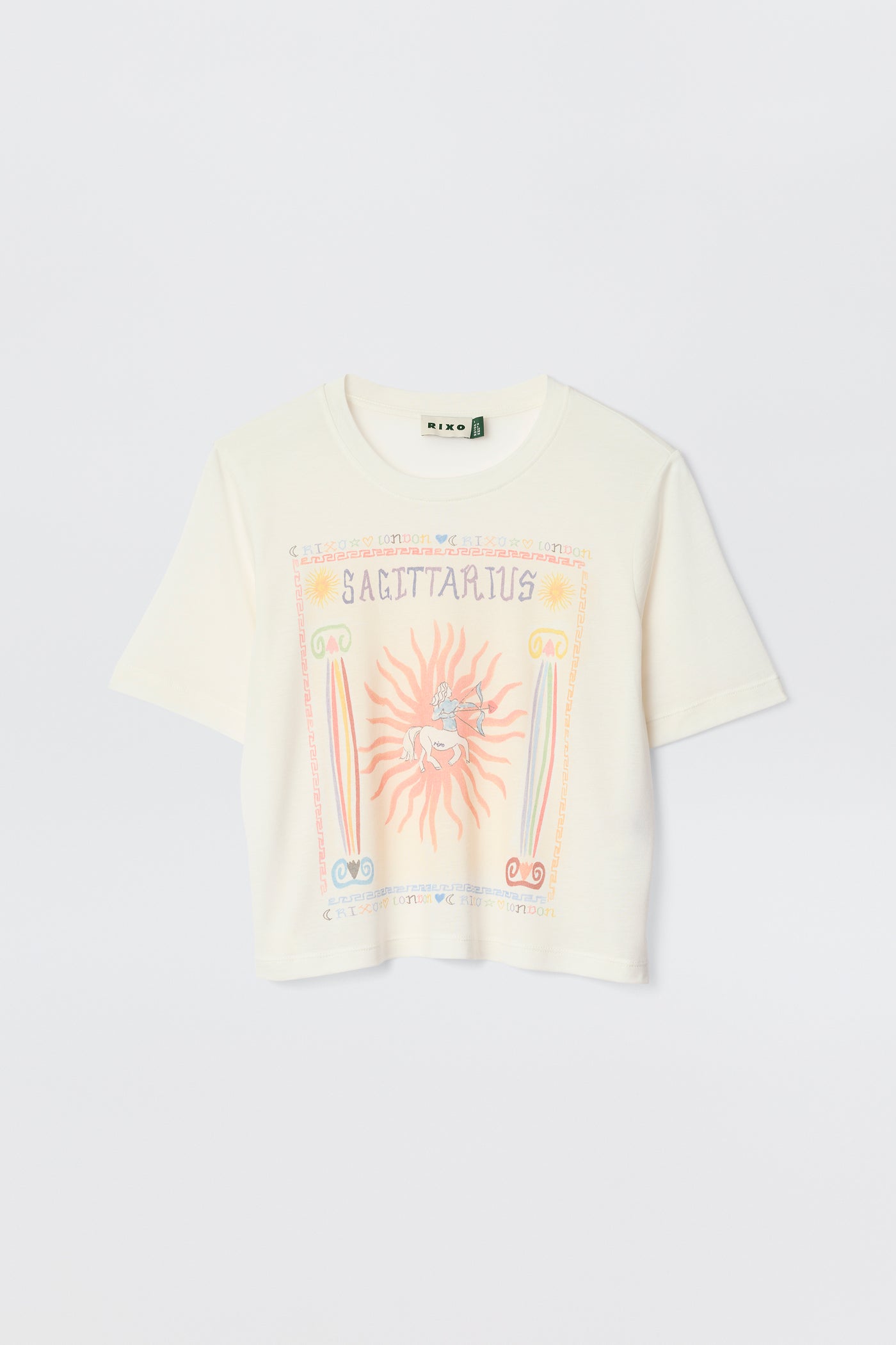 The Ria - Sagittarius is a white short-sleeve t-shirt with a colorful Sagittarius illustration, sun, rainbow, and astrological symbols on the front—perfect with RIXO skirts or styled with a trendy cropped hem.