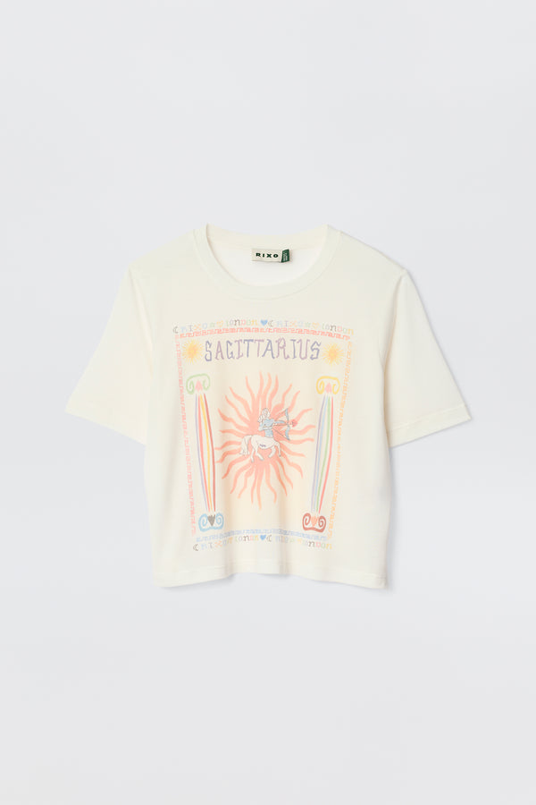 The Ria - Sagittarius is a white short-sleeve t-shirt with a colorful Sagittarius illustration, sun, rainbow, and astrological symbols on the front—perfect with RIXO skirts or styled with a trendy cropped hem.