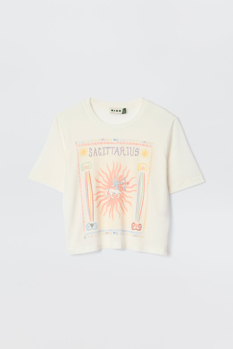 The Ria - Sagittarius is a white short-sleeve t-shirt with a colorful Sagittarius illustration, sun, rainbow, and astrological symbols on the front—perfect with RIXO skirts or styled with a trendy cropped hem.
