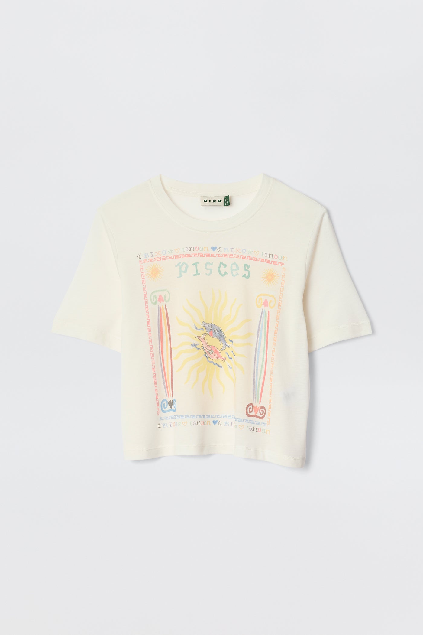 The Ria - Pisces is a white cropped hem T-shirt with a vibrant Pisces illustration—sun and fish at the center, surrounded by pastel astrological symbols and text. Pairs perfectly with RIXO skirts. Displayed against a plain background.