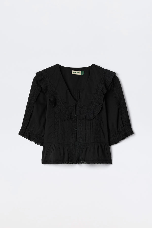 Ellery - Black: A vintage-inspired black cotton button-down top with a large lace-trimmed collar, 3/4 lace-detailed sleeves, and a ruffled hem, shown flat on a white background.