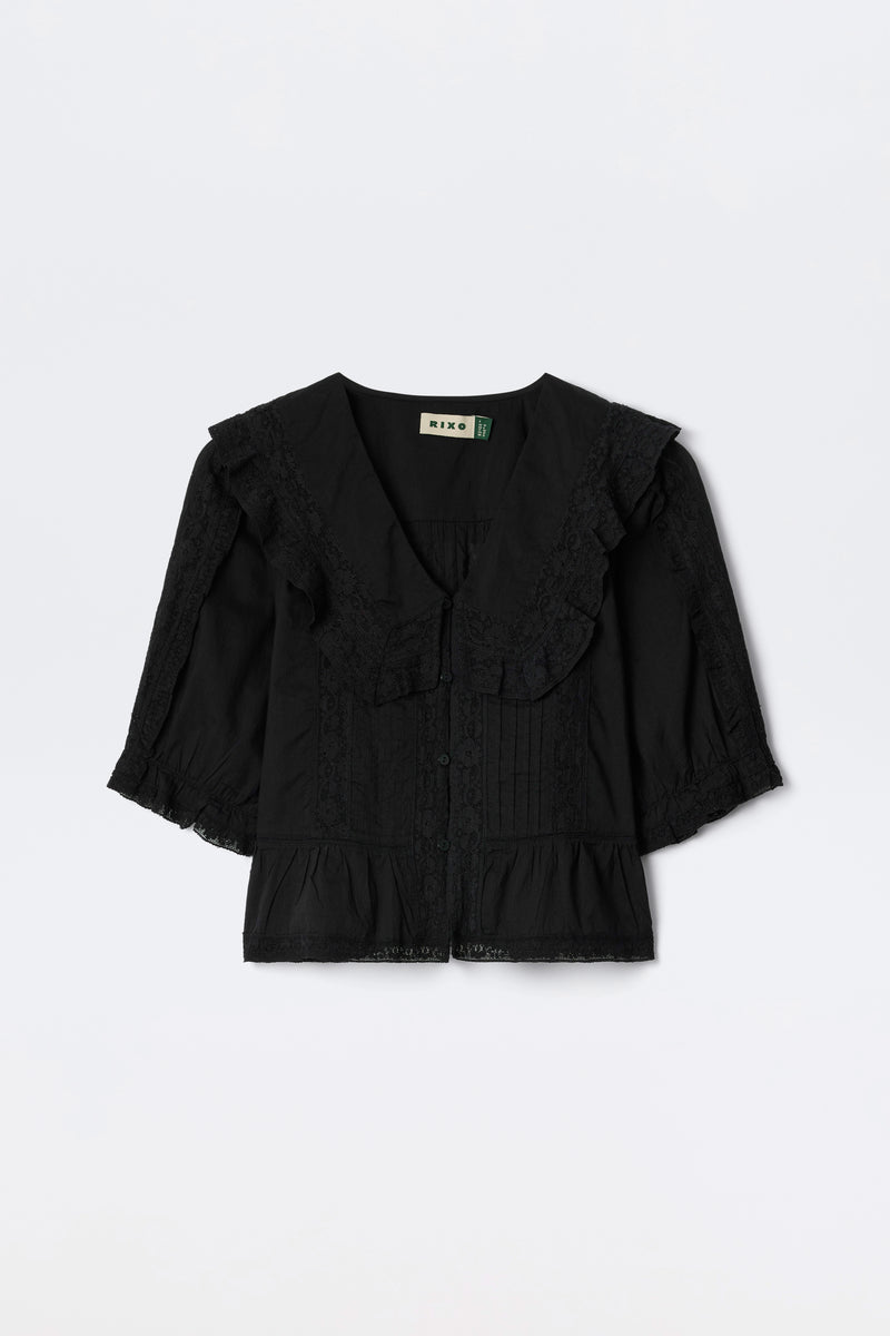 Ellery - Black: A vintage-inspired black cotton button-down top with a large lace-trimmed collar, 3/4 lace-detailed sleeves, and a ruffled hem, shown flat on a white background.