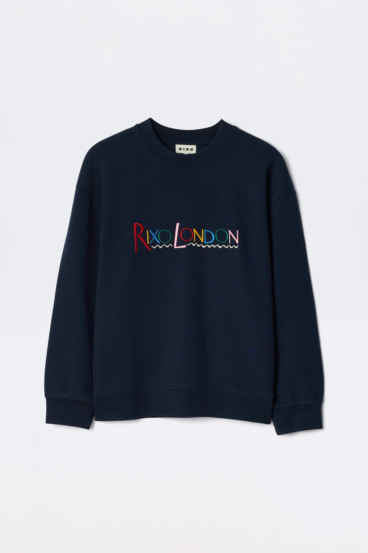The Blaze - London Embroidery Navy is a navy blue crewneck sweatshirt featuring RIXO LONDON in colorful, wave-underlined embroidery across the chest.