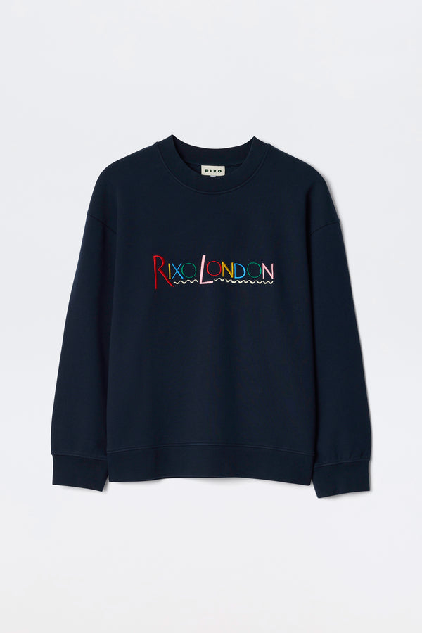 The Blaze - London Embroidery Navy is a navy blue crewneck sweatshirt featuring RIXO LONDON in colorful, wave-underlined embroidery across the chest.