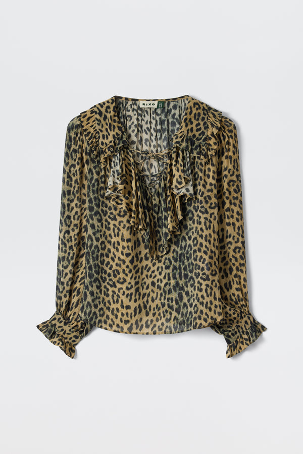 The Milia - Nina Leopard Brown blouse features long sleeves, a leopard print, and ruffled details at the collar and cuffs, shown against a plain white background.
