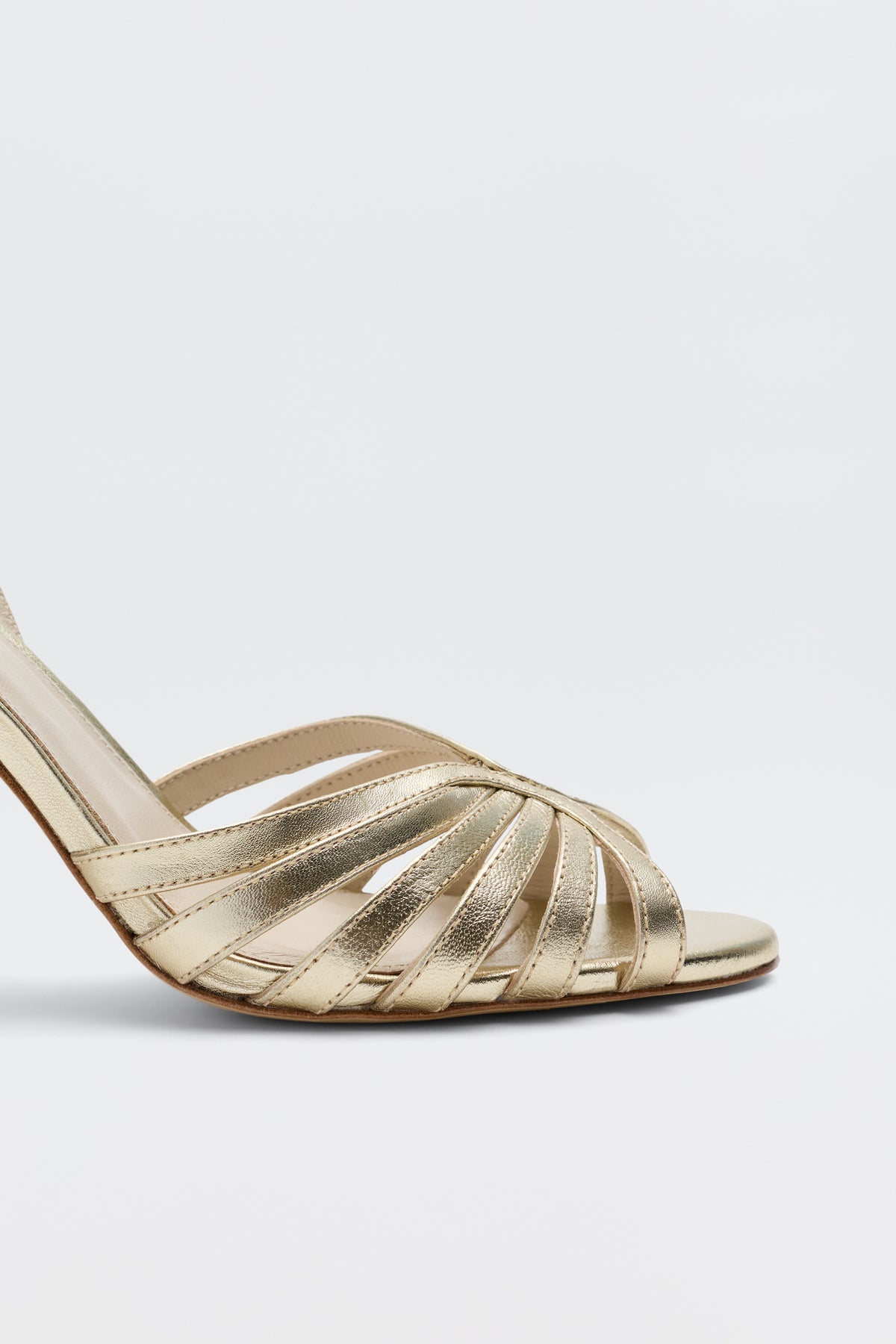 The Mavi - Gold sandals feature gold strappy high heels, open toes, and crisscrossing leather straps—a stunning women's footwear choice shown from a side angle against a plain white background.